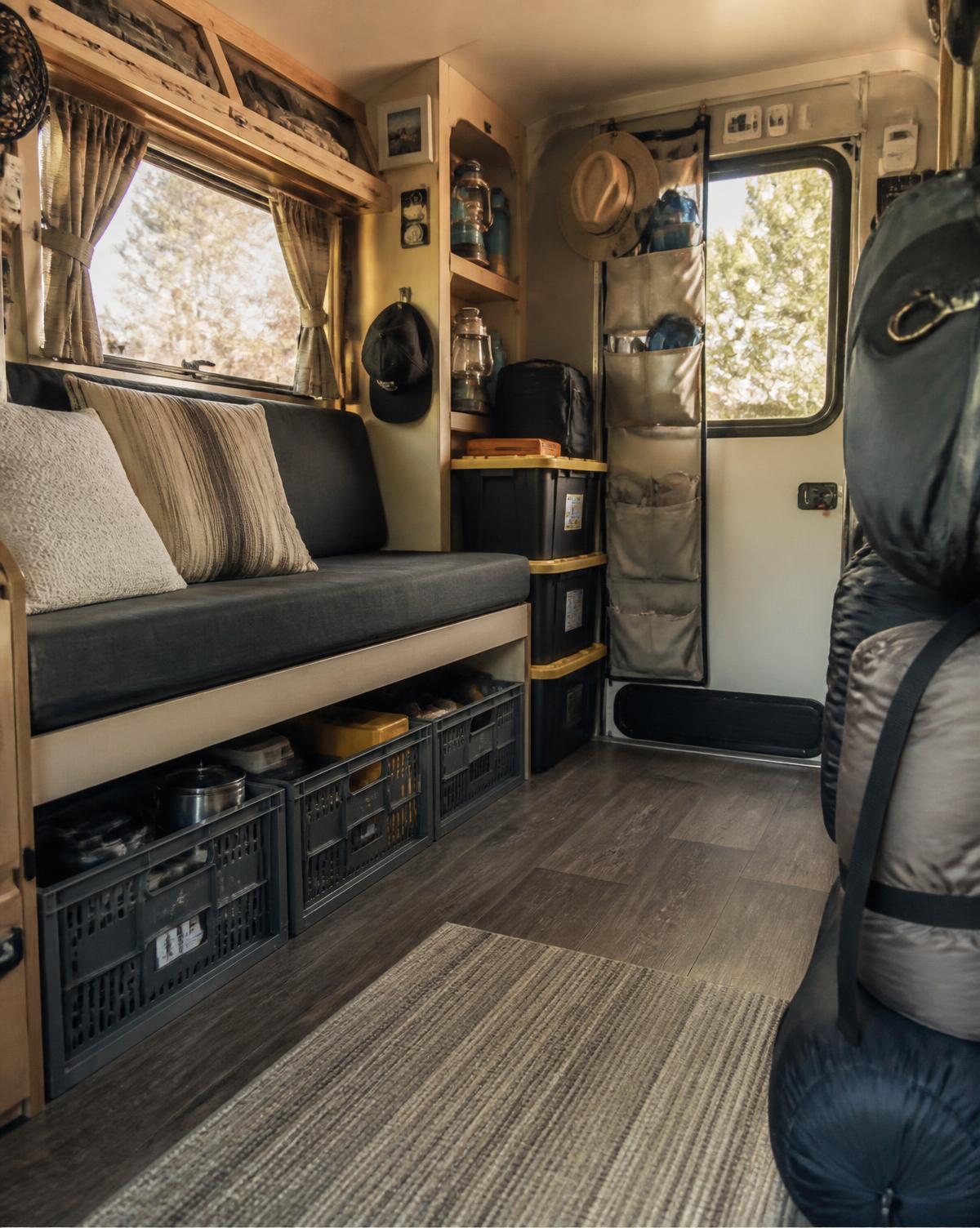 Same camper organized with crates, stacked bins and a hanging organizer